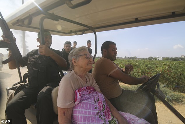 Palästinenser transportieren am Samstag einen gefangenen israelischen Zivilisten (Mitte) vom Kibbuz Kfar Azza in den Gazastreifen.  Die Militanten haben Dutzende, wenn nicht Hunderte Geiseln entführt