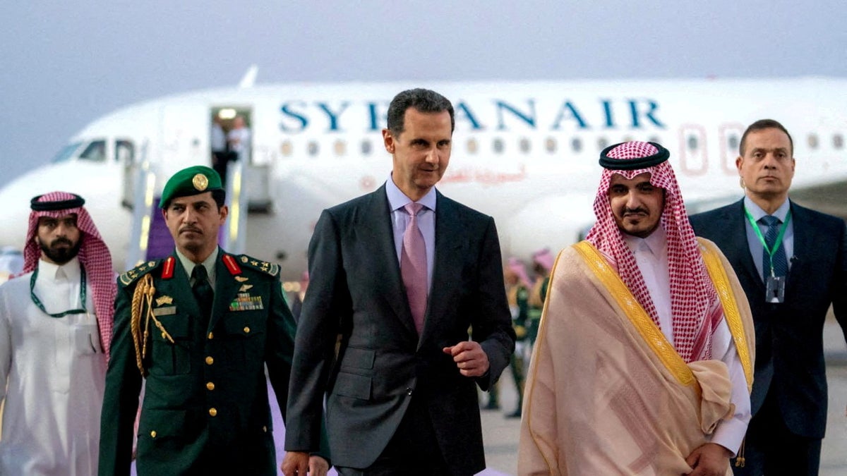 Syriens Präsident Bashar al-Assad läuft auf einem Rollfeld in Jeddah, Saudi-Arabien, mit einem Flugzeug hinter ihm