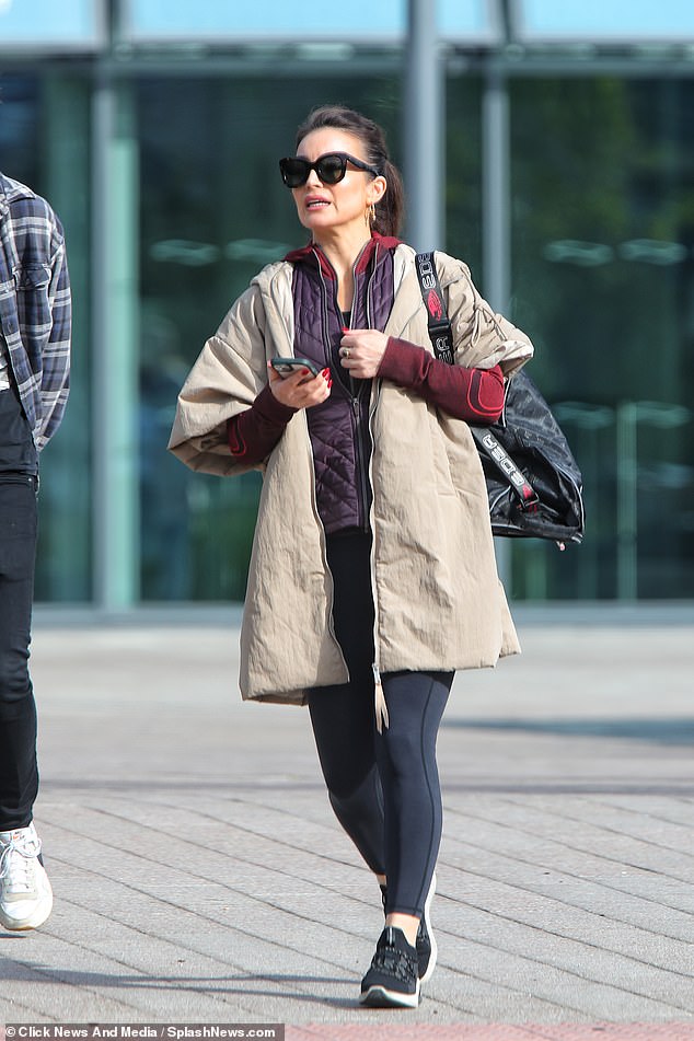 Layering them up: The star added a beige trench coat for another layer of warmth as she headed home after the training