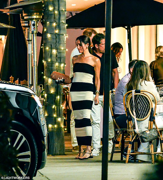In einem lässigeren, aber ebenso schicken Look entschied sich Meghan für ein schwarz-weißes Posse-Kleid im Röhrenstil für 188 £, um an einem Geburtstagsessen zu ihrem 42. Geburtstag in einem rustikalen italienischen Bistro in Montecito teilzunehmen