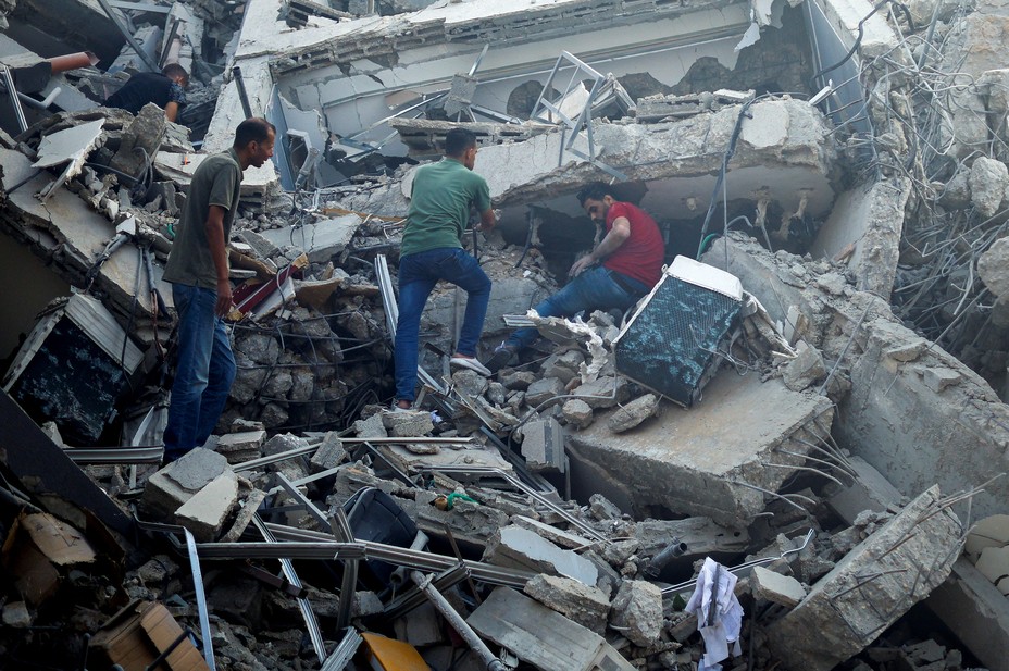 Bild von Palästinensern, die in den Trümmern des Watan-Turms, der bei israelischen Angriffen zerstört wurde, in Gaza-Stadt nach Hab und Gut suchen, 8. Oktober 2023. REUTERS/Mohammed Salem