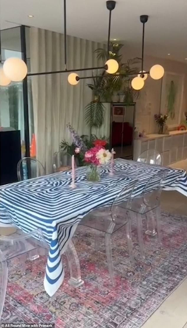 Schick: Die Wohnküche verfügt über einen durchsichtigen Tisch und Stühle, die auf einem bunten Teppich platziert sind