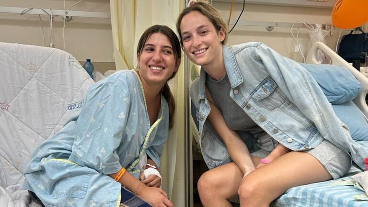 Noa Ben Artzi und Michele sitzen lächelnd auf Krankenhausbetten