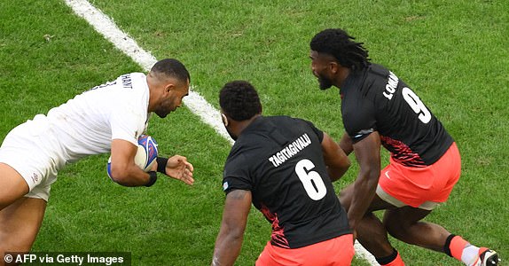 England's outside centre Joe Marchant (L) scores a try despite Fiji's blindside flanker Lekima Tagitagivalu (C) and Fiji's scrum-half Frank Lomani during the France 2023 Rugby World Cup quarter-final match between England and Fiji at the Velodrome stadium in Marseille, south-eastern France, on October 15, 2023. (Photo by NICOLAS TUCAT / AFP) (Photo by NICOLAS TUCAT/AFP via Getty Images)