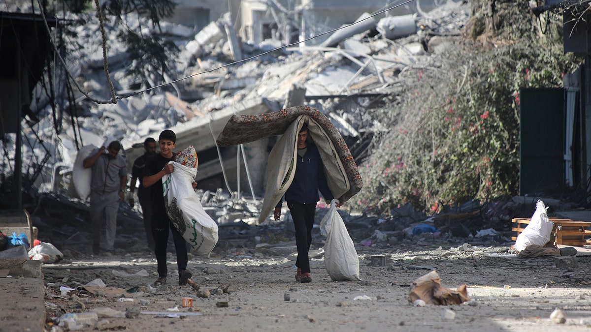 Palästinenser gehen von beschädigten Gebäuden weg