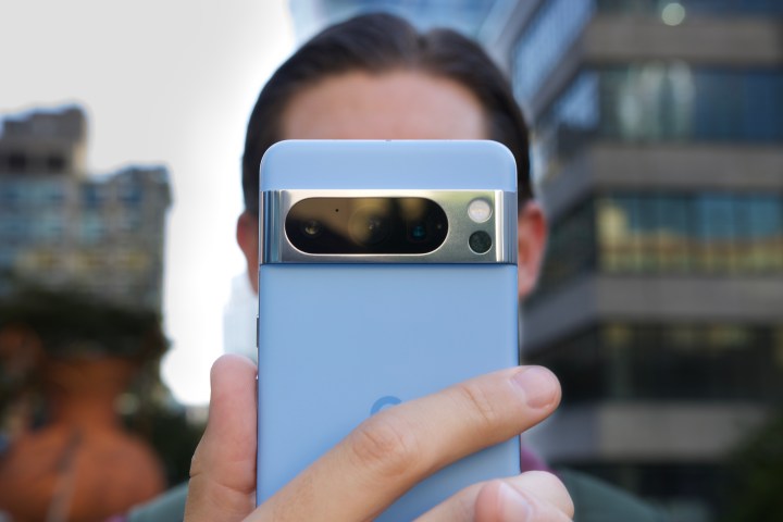 Someone holding the blue Google Pixel 8 Pro in front of their face.