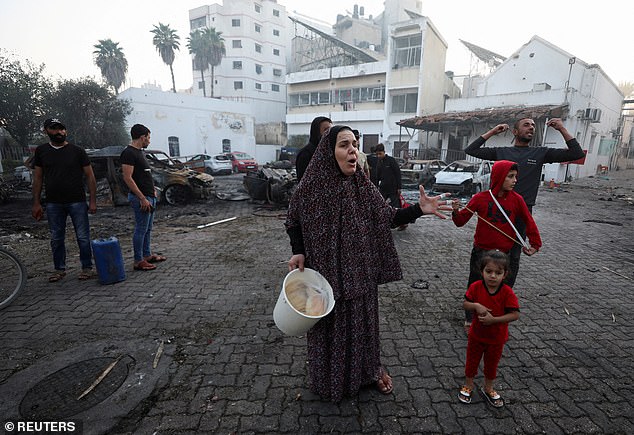 People react at the area of Al-Ahli hospital, where hundreds of Palestinians were killed in a blast that Israeli and Palestinian officials blamed on each other in Gaza City on Wednesday