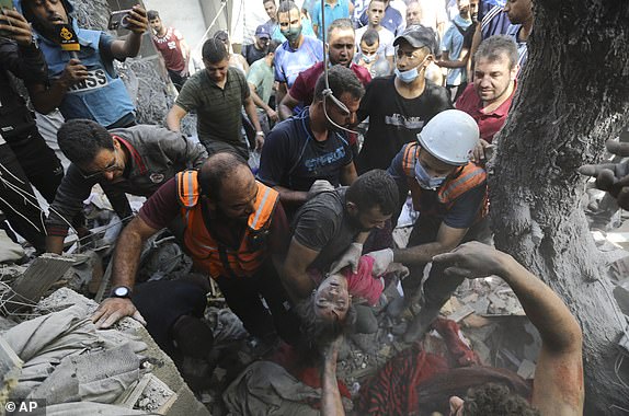 Palestinians rescue a child from under the rubble after Israeli airstrikes in Gaza City, Gaza Strip, Wednesday, Oct. 17, 2023. (AP Photo/Abed Khaled)