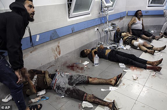 Wounded Palestinians lie on the floor in al-Shifa Hospital in Gaza City, central Gaza Strip, after arriving from al-Ahli Hospital following an explosion there, Tuesday, Oct. 17, 2023. The Hamas-run Health Ministry says an Israeli airstrike caused the explosion that killed hundreds at al-Ahli, but the Israeli military says it was a misfired Palestinian rocket. (AP Photo/Abed Khaled)