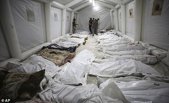 Bodies of Palestinians killed by an Israeli airstrike that hit the Ahli Arab hospital are seen gathered at the front yard of the al-Shifa hospital, in Gaza City, central Gaza Strip, Tuesday, Oct. 17, 2023. (AP Photo/Abed Khaled)