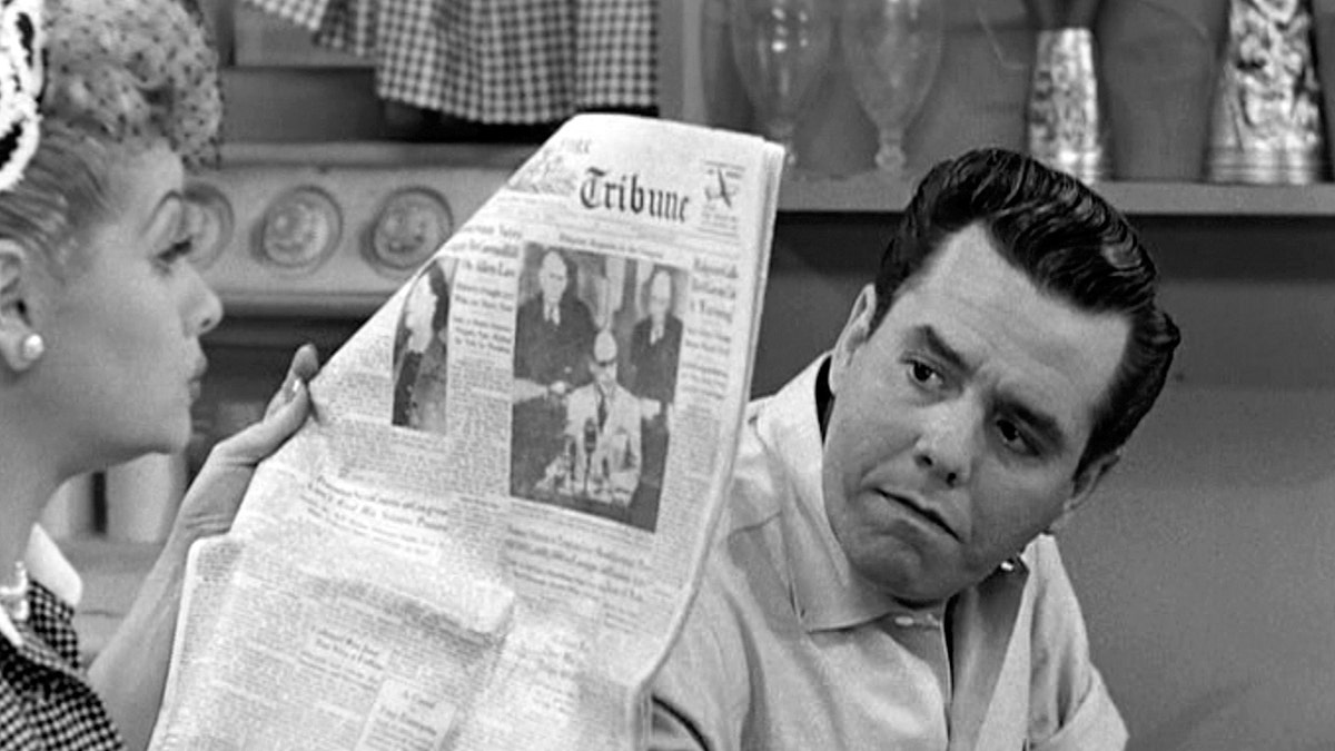 Desi Arnaz sieht verärgert aus, als Lucille Ball ihn ignoriert und eine Zeitung liest