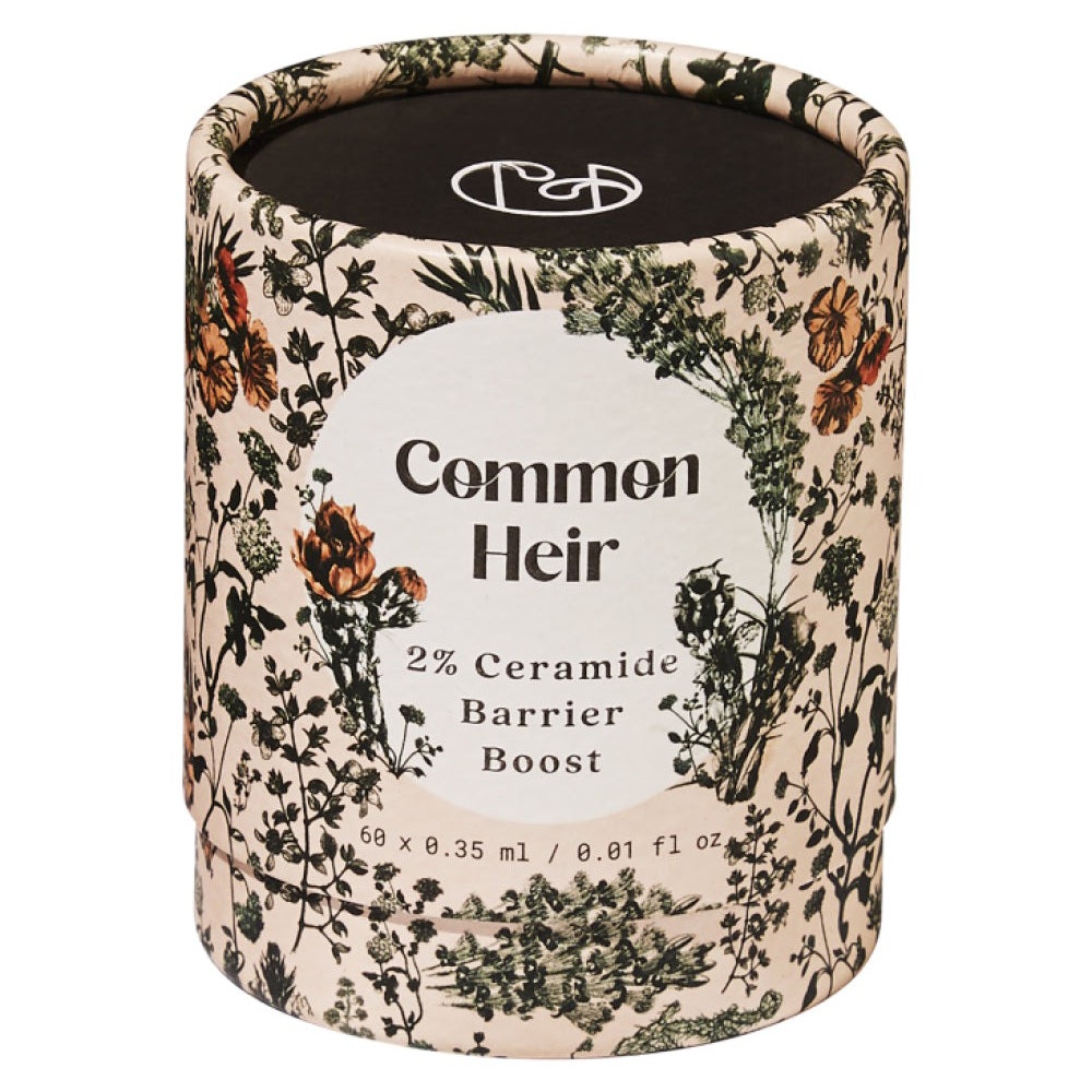 Common Heir 2 % Ceramide Barrier Boost Serum, beige Zylinderbehälter mit Blumenmuster auf weißem Hintergrund