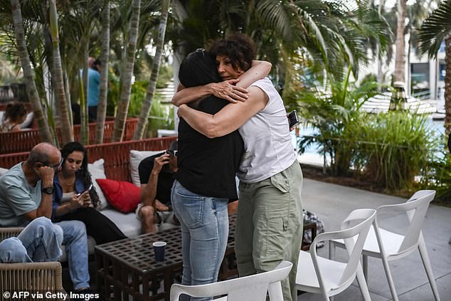 Two women hug each other at a hotel in the southern city of Eilat on October 17, 2023, which is hosting survivors from the Israeli kibbutz of Nir Oz