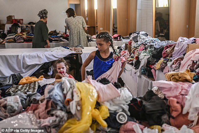 People receive clothes from donations at a hotel in the southern city of Eilat
