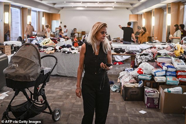 A woman walks in a hall where donated clothes are provided in the southern city of Eilat