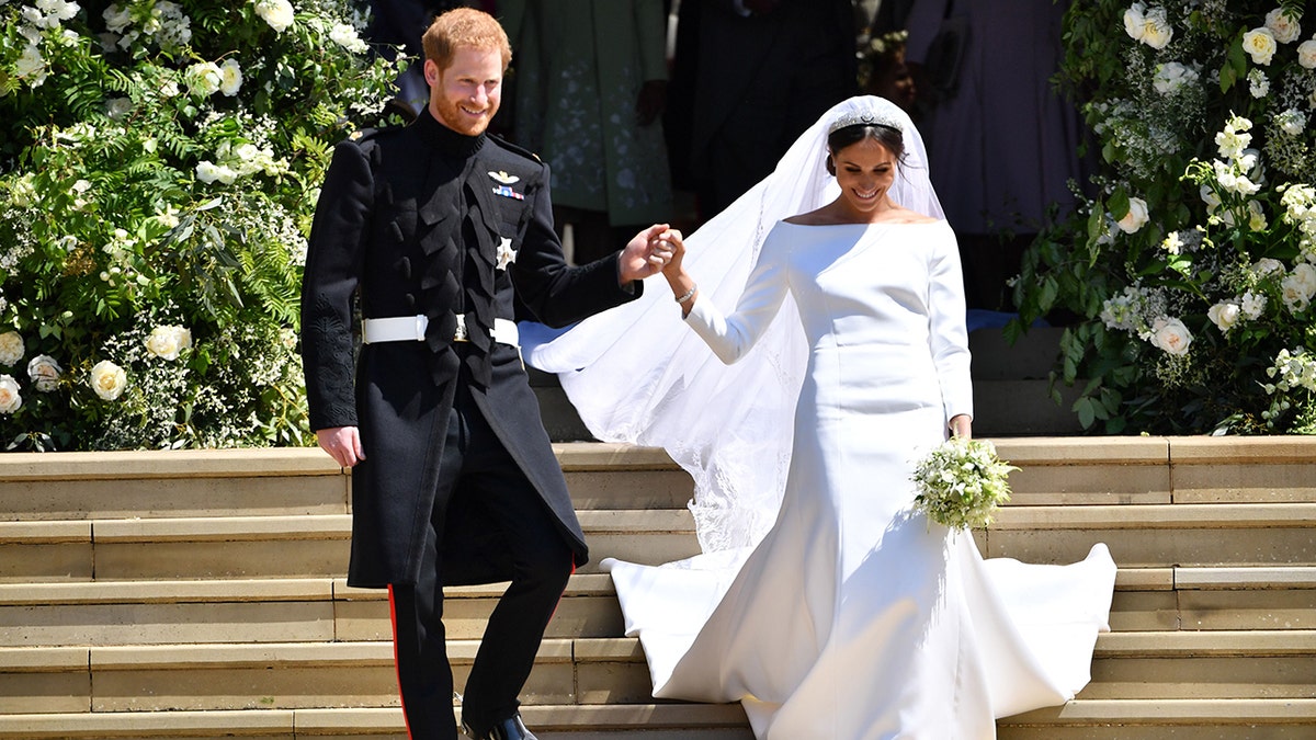 Prinz Harry hält Meghan Markles Hand, als sie die Treppe zur George's Chapel hinuntergehen, wo sie gerade auf Schloss Windsor geheiratet haben