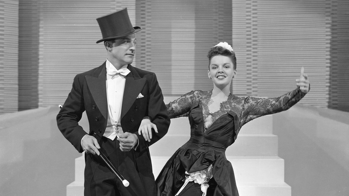 Gene Kelly mit Zylinder und Frack tanzt mit Judy Garland in einem glamourösen Kleid