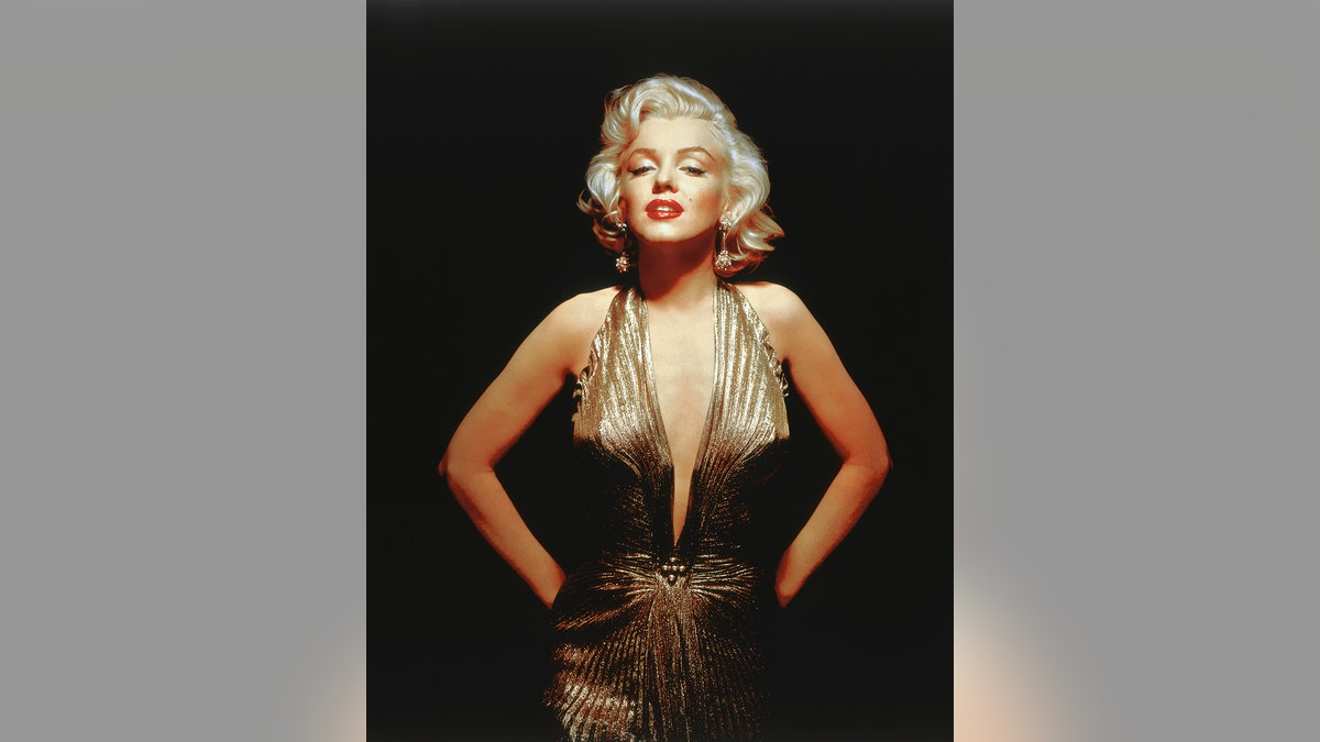 Marilyn Monroe trägt ein tief ausgeschnittenes goldenes Kleid