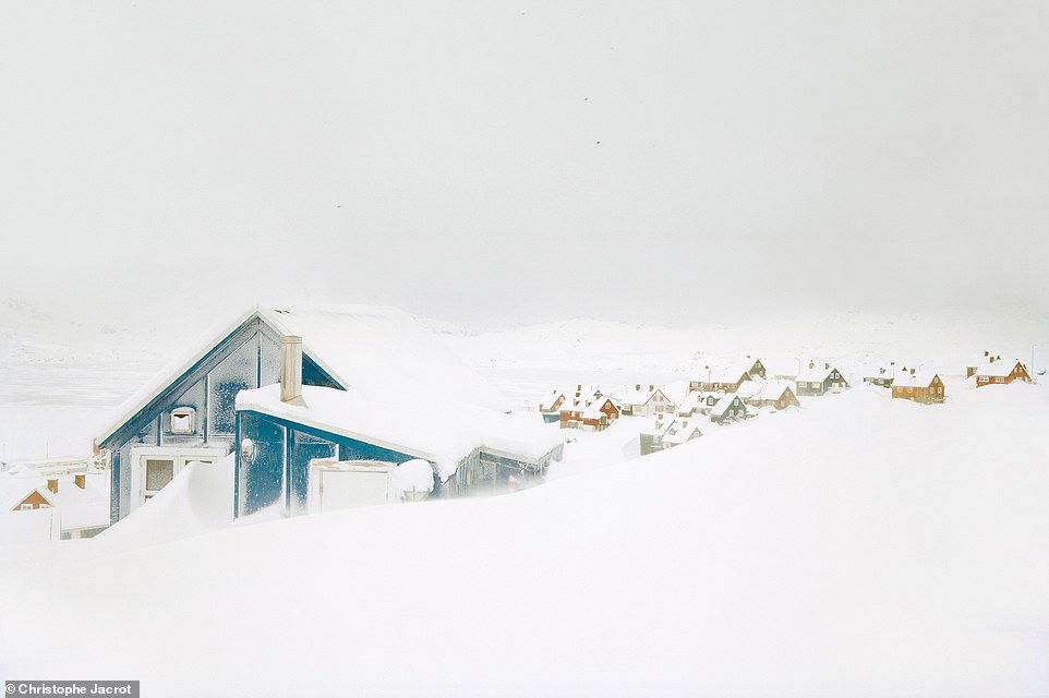 Dieses im Schnee vergrabene blaue Retro-Häuschen wurde in der Stadt Tasiilaq im Osten Grönlands aufgenommen
