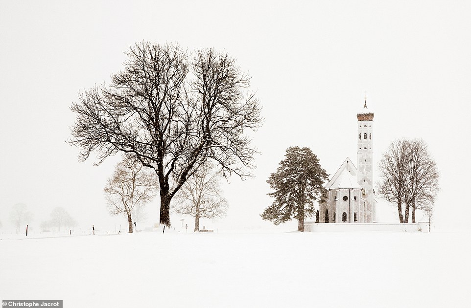 Dieses bezaubernde Foto zeigt die schneebedeckte Landschaft rund um die St. Coloman-Kirche in Bayern, Deutschland