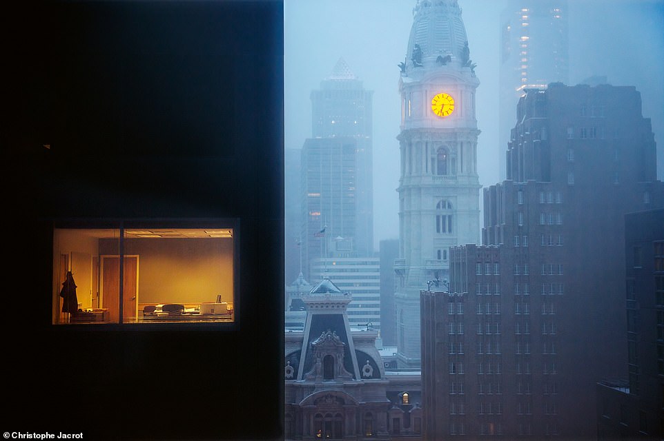 In dieser atemberaubenden Aufnahme bringt das Licht des Uhrturms des Rathauses einen warmen Glanz in die nebligen Straßen von Philadelphia, Pennsylvania