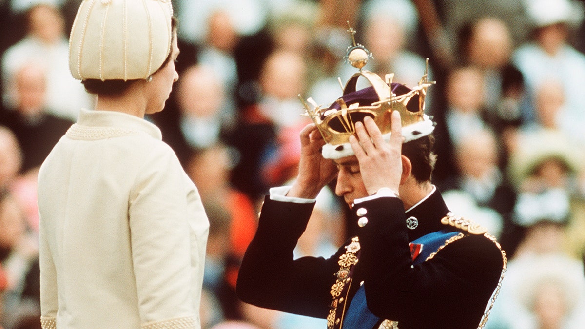Prinz Charles wird gekrönt, während er vor Königin Elizabeth kniet