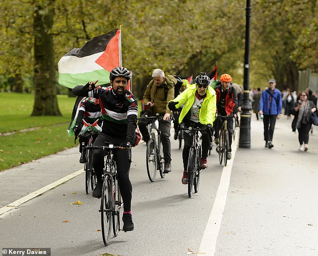 Cyclists bearing Palestine flags travel through central London on Saturday