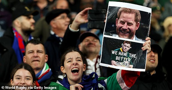 PARIS, FRANCE - OCTOBER 21: A fan of South Africa poses for a photo holding a banner that features imagery of Prince Harry, Duke of Sussex and Steven Kitshoff of South Africa prior to the Rugby World Cup France 2023 match between England and South Africa at Stade de France on October 21, 2023 in Paris, France. (Photo by Michael Steele - World Rugby/World Rugby via Getty Images)