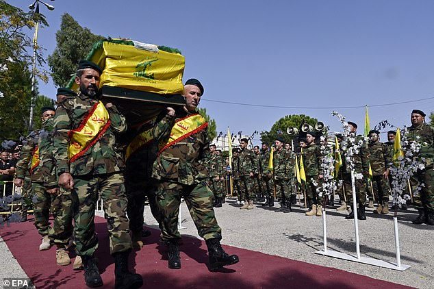 Fighters of the Lebanese militant group Hezbollah carry the coffin of Hezbollah fighter Bilal Rmeity, who was killed by Israeli shelling in Lebanese border towns with Israel