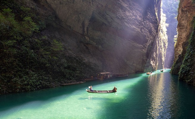 Touristen machen eine Bootsfahrt durch den Pingshan Grand Canyon im Kreis Hefeng, China.