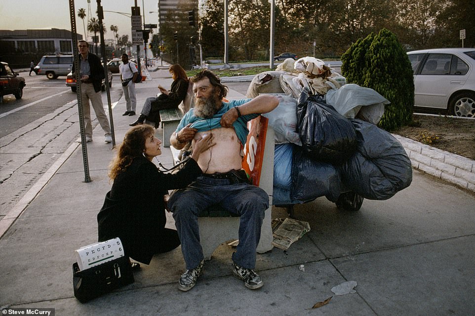 Hier fängt Steve McCurry den zarten Moment ein, als eine Krankenschwester in Los Angeles, Kalifornien, die Vitalfunktionen eines Obdachlosen überprüft
