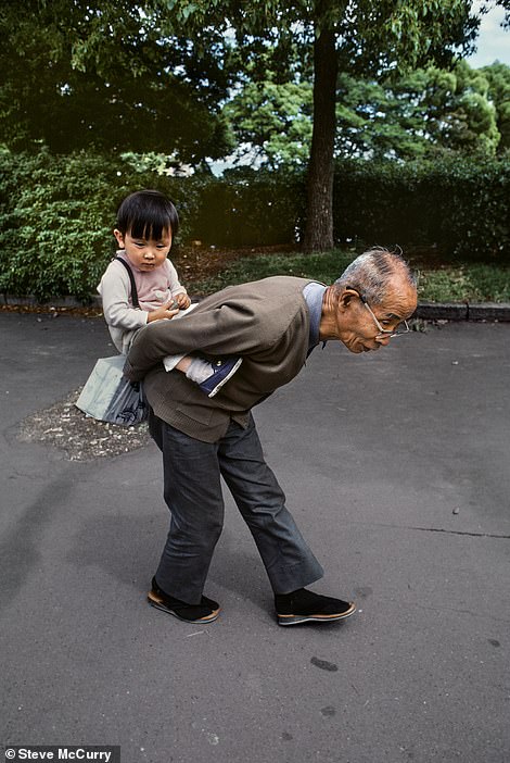 Dieses herzerwärmende Foto aus dem Jahr 1985 zeigt einen Großvater, der seinen Enkel auf dem Rücken trägt.  Es wurde von McCurry in Tokio, Japan, aufgenommen