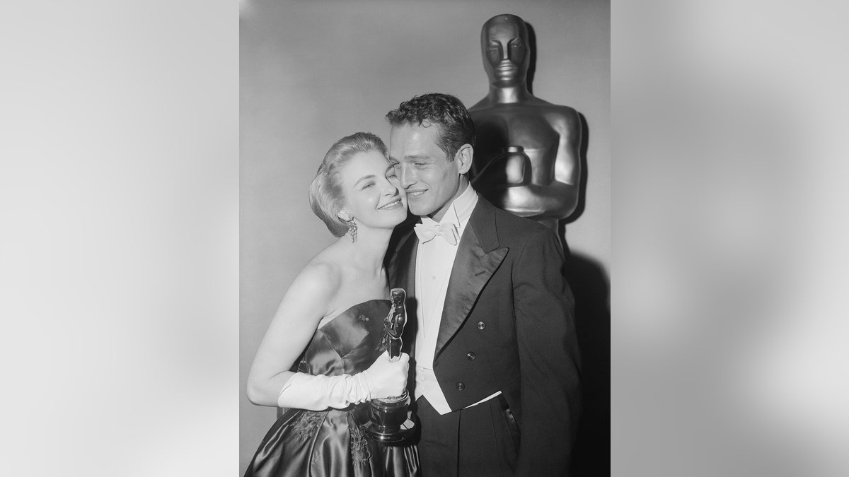 Joanne Woodward lächelt und knutscht mit Paul Newman, während sie ihren Oscar-Preis in der Hand hält