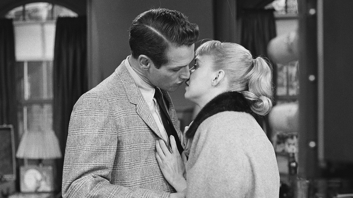 Paul Newman beugt sich zu einem Kuss von Joanne Woodward vor