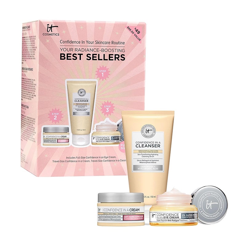 IT Cosmetics Radiance Boosting Bestseller-Hautpflege-Geschenkset: Zwei hellgelbe Gläser mit silbernen Deckeln und einer passenden Tube neben einer rosa Geschenkbox auf weißem Hintergrund