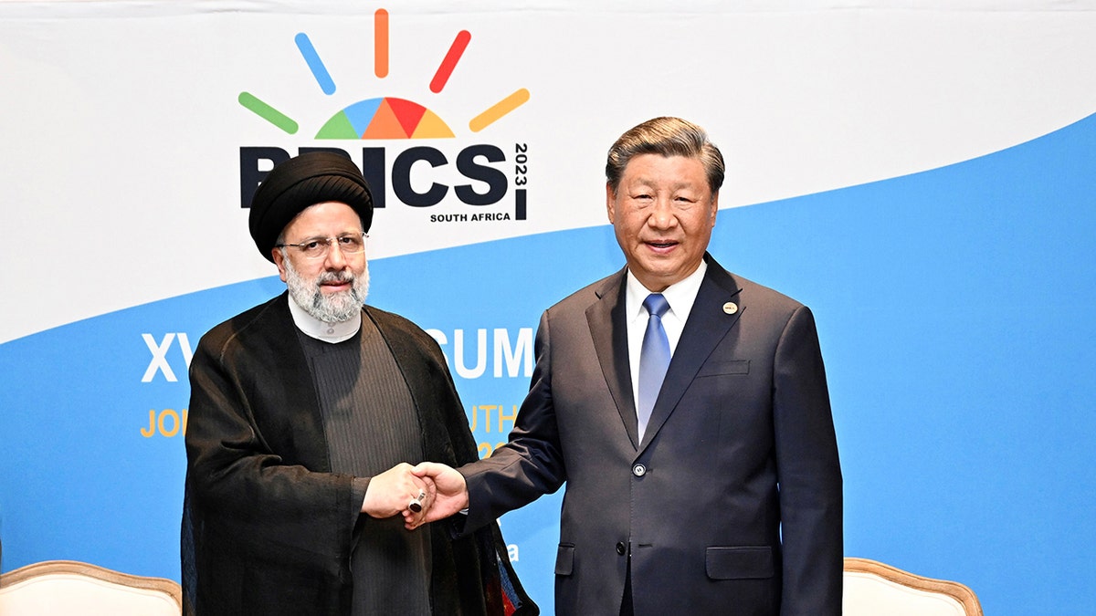 Der iranische Präsident Ebrahim Raisi schüttelt dem chinesischen Präsidenten Xi Jinping die Hand