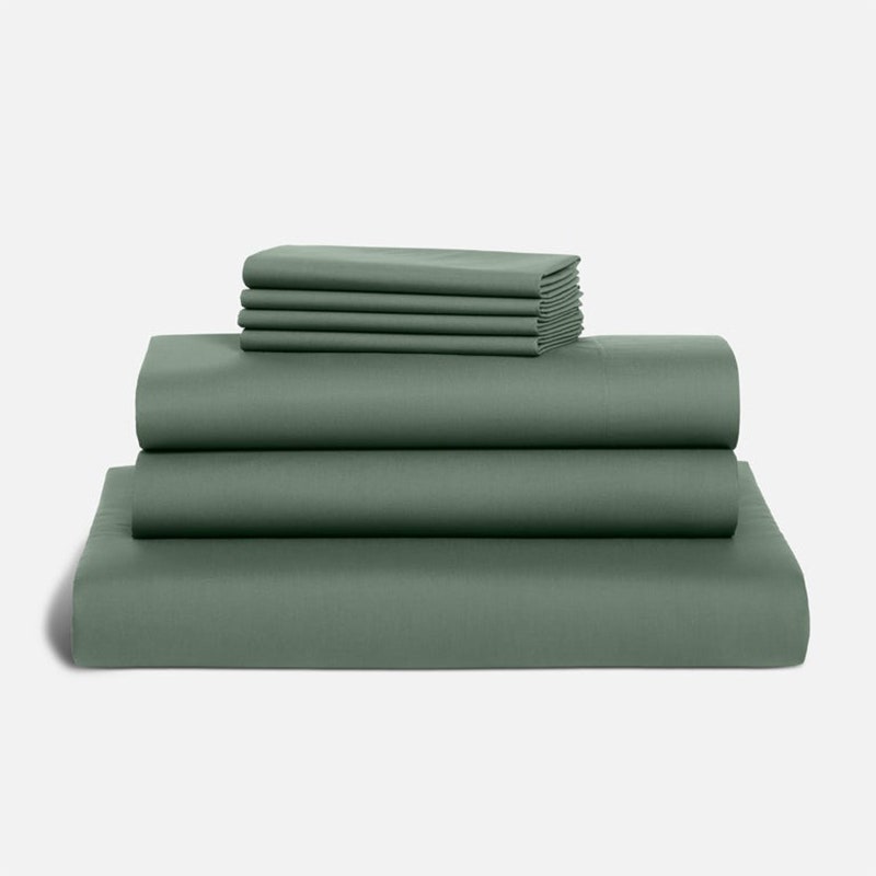 Luxe Sateen Hardcore Sheet Bundle: ein siebenteiliges dunkelgrünes Bettlaken-Set auf grauem Hintergrund