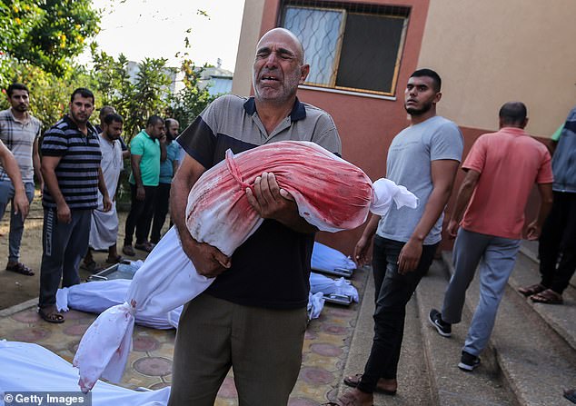 Israel says it is expanding its ground operation tonight. Pictured: Mourners collect the bodies of Palestinians killed in Israeli raids on Friday