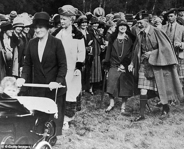 Königin Elizabeth II. wird in ihrem Silver Cross-Kinderwagen geschoben, gefolgt von Königin Mary im Jahr 1927, der Königinmutter, König Georg V. und ihrem Vater König Georg VI. durch das Gelände von Balmoral