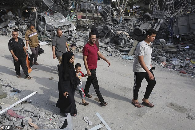 Palestinians walking through the wreckage of a bombing campaign in Rafah, southern Gaza