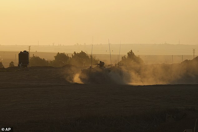 An Israeli armored personnel carrier moves near the Gaza Strip border, where troops for the Jewish nation have massed in southern Israel