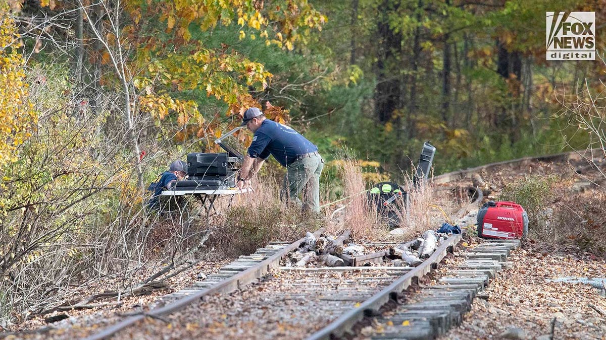 Polizeibeamte helfen bei der Suche nach Robert Card entlang der nahegelegenen Eisenbahnschienen am Androscoggin River