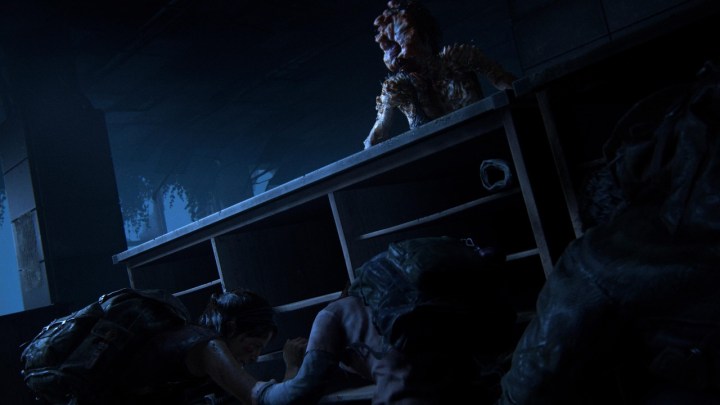 Ellie und Joel verstecken sich in The Last of Us Remake hinter einem Schreibtisch vor einem Clicker.