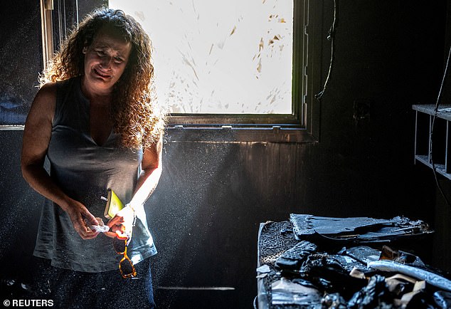 Hadas Kalderon, whose two children Erez and Saha and their father Ofir have been kidnapped, while Hadas' mother and niece were killed, cries in the burned-out remains of her mother's home, following a deadly attack by Hamas gunmen from the Gaza Strip on Kibbutz Nir Oz on Monday
