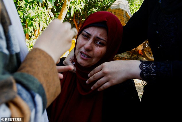 A woman cries near the bodies of Palestinians killed in Israeli strikes during their funeral, in Khan Younis in the southern Gaza Strip on Tuesday
