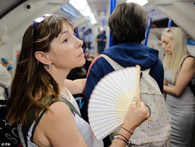 Anyone who regularly uses the London Underground in the summer will attest to the baking heat and sweltering conditions. Pictured: A woman uses a fan to cool down on a tube train in central London