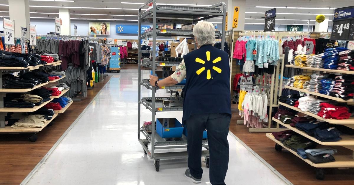 Ein Walmart-Mitarbeiter schiebt einen Einkaufswagen durch eine Walmart-Filiale