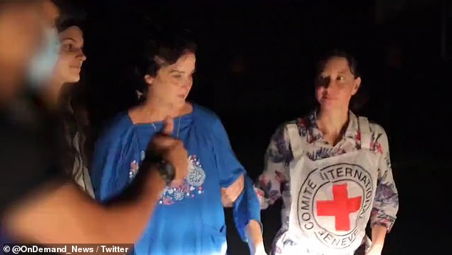 Judith Raanan is seen being escorted out of Gaza on Friday, with her daughter Natalie to her right