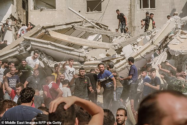 Menschen versammeln sich am Dienstag um ein durch israelische Luftangriffe zerstörtes Gebäude, um verletzte Zivilisten zu retten und Leichen aus den Trümmern zu bergen