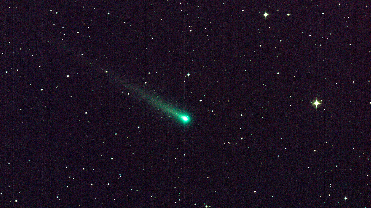 Hellgrüner Komet strahlt durch den Nachthimmel